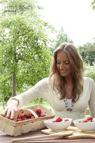 Junge Frau sitzt im Garten