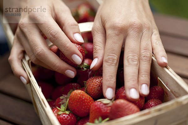 Hand an Erdbeeren