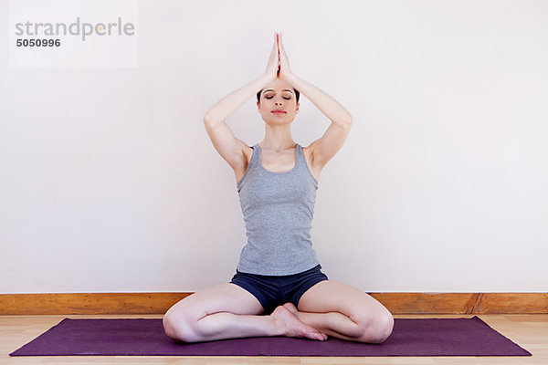 Frau in Gebetsposition während des Yoga
