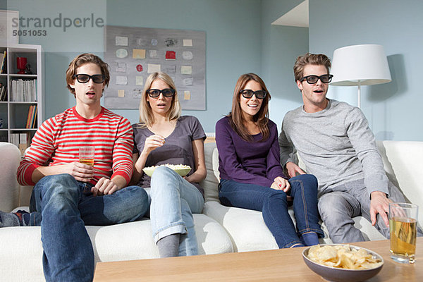Vier Freunde sehen sich zu Hause einen 3D-Film an.
