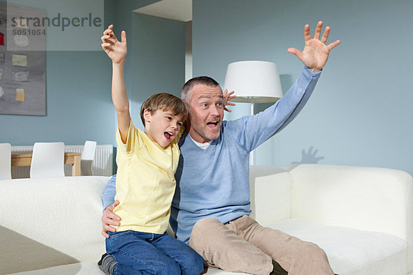 Vater und Sohn beim Jubeln im Fernsehen