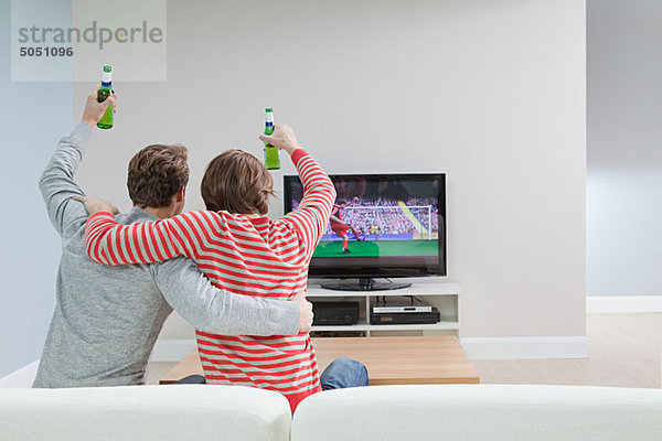 Zwei junge Männer beim Fußball im Fernsehen