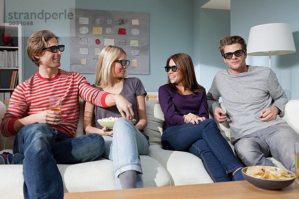 Vier Freunde sehen sich zu Hause einen 3D-Film an.