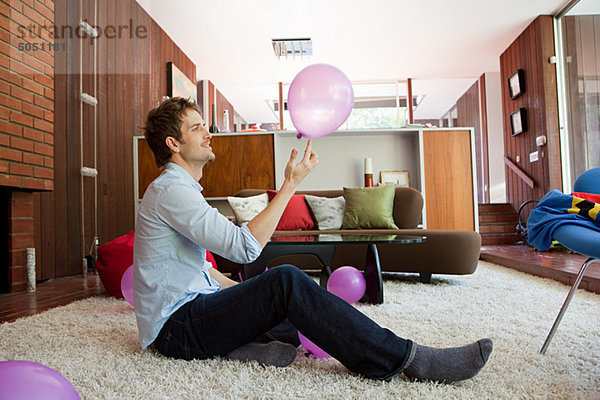 sitzend Mann Boden Fußboden Fußböden Zimmer Luftballon Ballon pink Wohnzimmer spielen