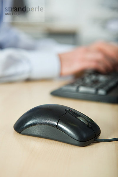 Office worker using computer  mouse in foreground