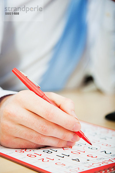 Büroberuf Kalender mit roter Stift markieren