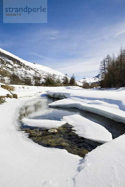 Eisschollen schwimmen auf dem Fluss in verschneiter Landschaft