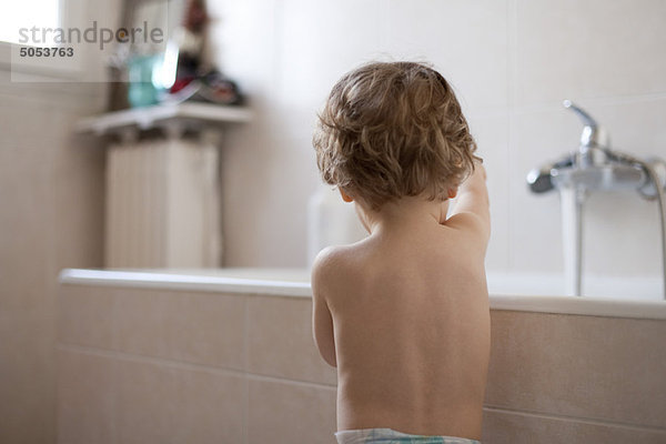 Kleinkind beim Badewannenspiel  Rückansicht