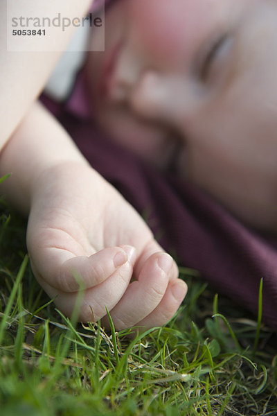 Baby Mädchen schläft auf Gras