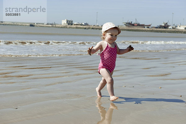 Kleinkind Mädchen  das am Strand spazieren geht