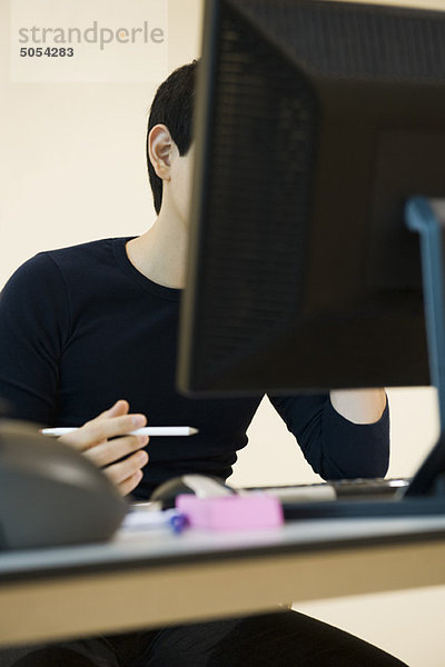 Büroangestellter am Schreibtisch mit Computer