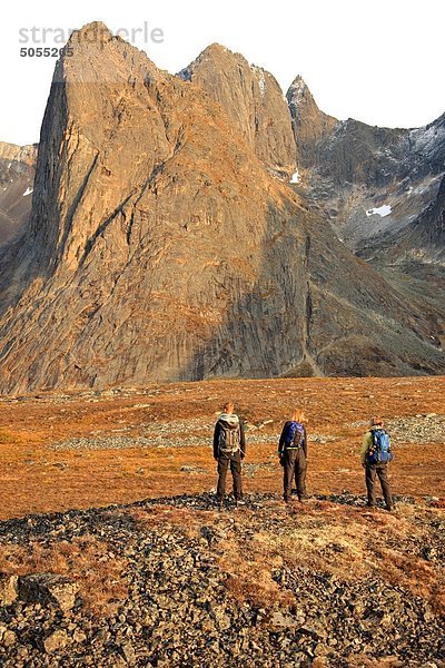 Drei Wanderer stehend auf einem Felsen Haufen bei Sonnenuntergang Blick auf Mount Monolith in Tombstone Territiorial Park  Yukon.