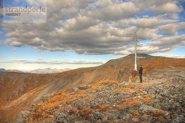 Zwei Personen  Vater und Sohn am Wegweiser über Keno Hill  Yukon stehen. Die Werneke-Berge sind Oin der Abstand.