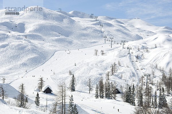 Vogel-Skigebiet in den Julischen Alpen in Slowenien  zeigt eine Sesselbahn  Skifahrer und Pisten mit Spuren im Schnee
