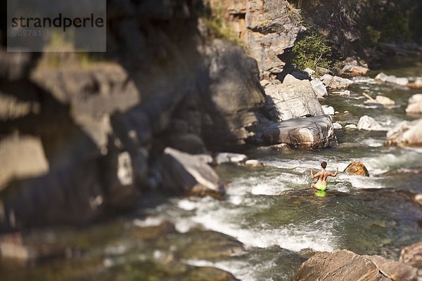 Eine junge Frau  die Schwimmen unter Moyie Wasserfall  Cranbrook  British Columbia  Kanada