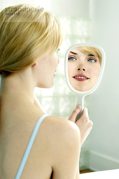 Frau gerade ihr Gesicht im Spiegel
