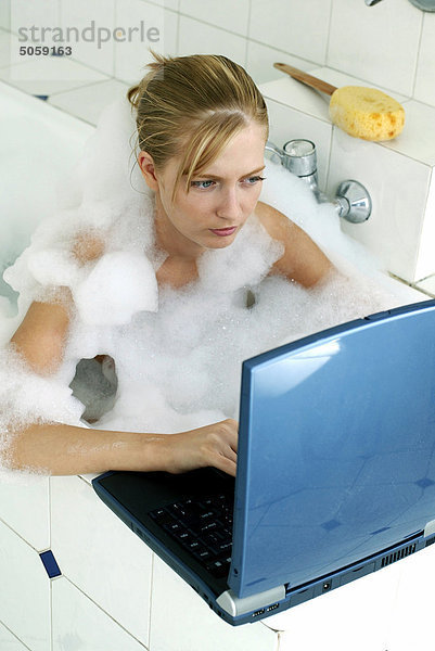 Weiblich working Laptop in Badewanne