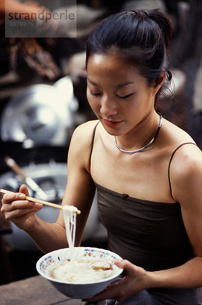 Thailand  Bangkok  asian Woman eating Nudeln mit Stäbchen