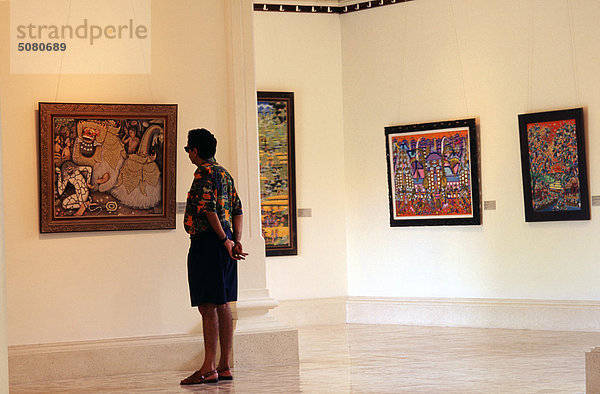 Tourist Blick auf die balinesische Malerei im Kunstmuseum. Bali  Indonesien.