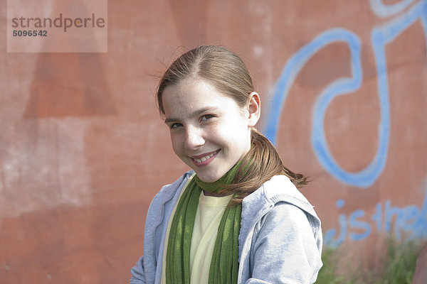 Lächelndes Mädchen vor einer Graffitiwand  Portrait