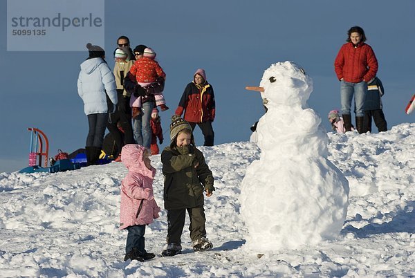 Österreich  Kärnten  Villach  Naturpark Dobratsch  Kinder spielen eines Schneemannes