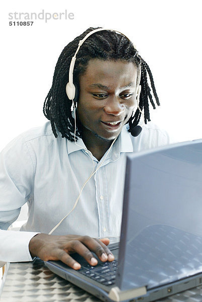 Afro-American Mann mit Kopfhörer und laptop