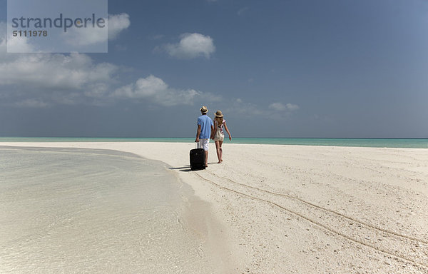 Paar Rollgepäck am Strand