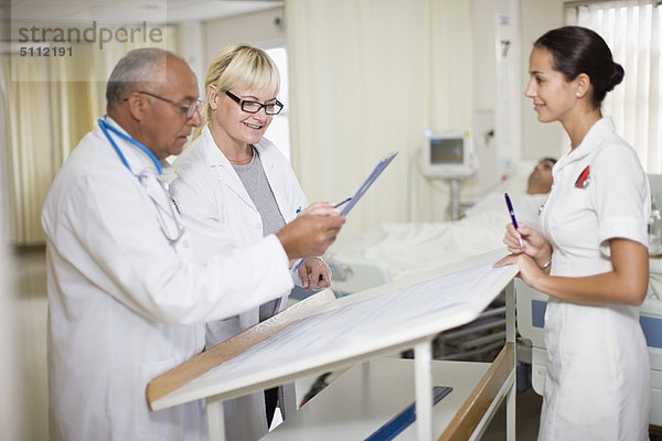 Ärzte mit Krankenschwester im Krankenhauszimmer