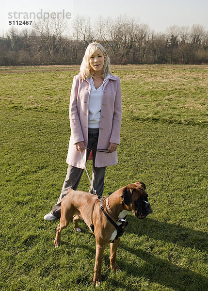 Frau spazieren gehender Hund im Feld