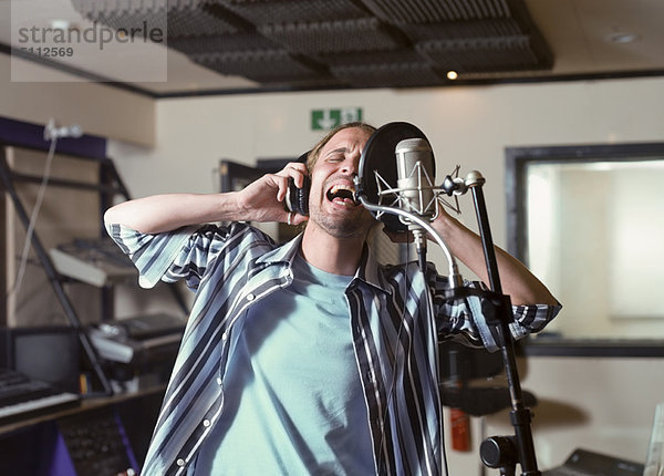 Mann singt im Tonstudio