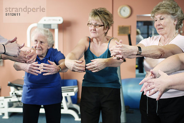 Ältere Frauen beim Stretching im Fitnessstudio