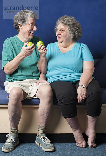 Das ältere Paar isst zusammen Äpfel.
