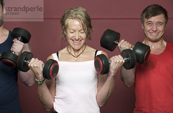 Ältere Menschen beim Gewichtheben im Fitnessstudio