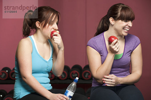 Frauen essen Äpfel im Fitnessstudio