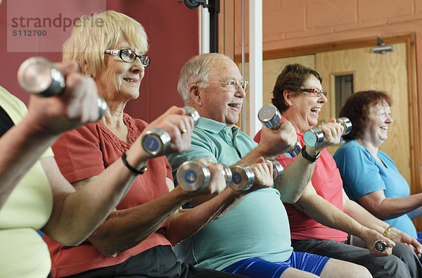 Ältere Menschen beim Gewichtheben im Fitnessstudio