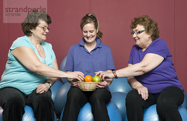 Ältere Frau mit Obst im Fitnessstudio