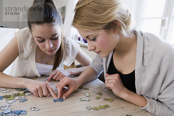 Teenagermädchen arbeiten am Puzzle