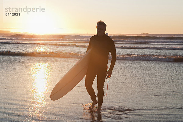 Surfer beim Wandern im Wasser