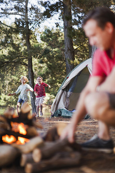 Kinder laufen zum Vater auf dem Campingplatz