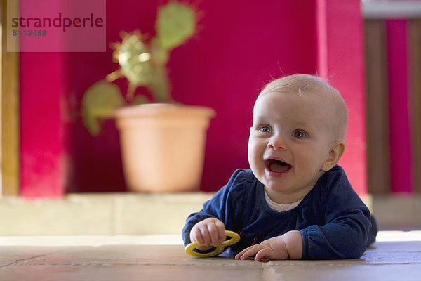 Lächelndes Baby krabbelt auf dem Boden