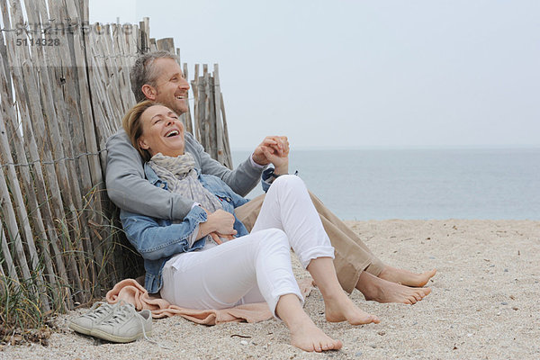 Ältere Paare umarmen sich am Strand