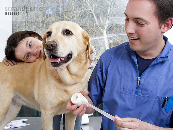 Tierarzt bei der Arbeit mit Mädchen und Hund