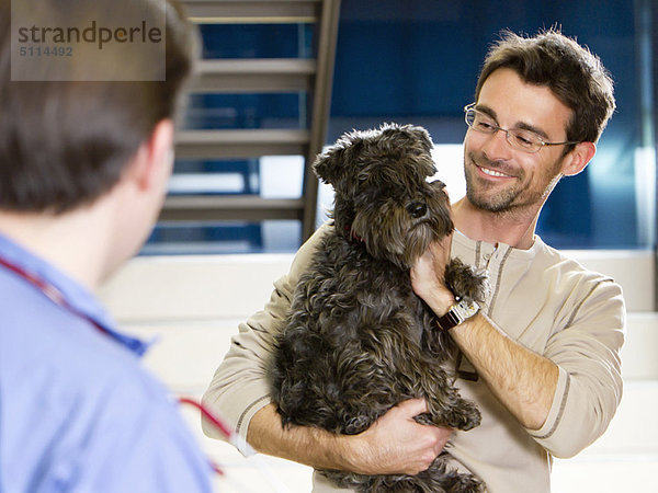 Mann  halten  Hund  Tierarzt