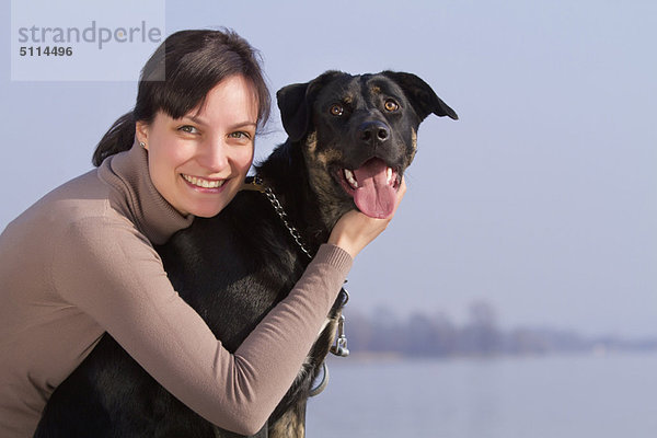 Außenaufnahme  Frau  umarmen  Hund  freie Natur