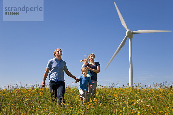 Familienwanderung im Feld mit Windkraftanlage
