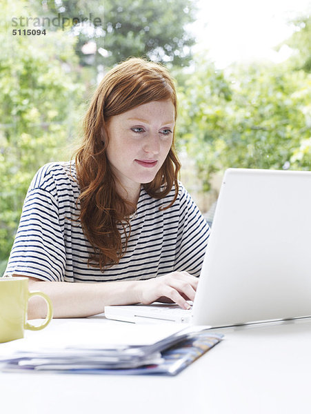 Frau mit Laptop im Haus