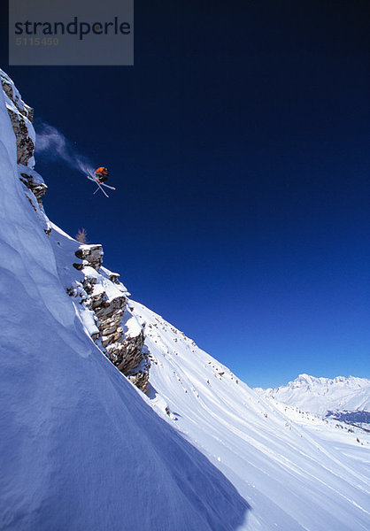 Skifahrer beim Sprung am Hang