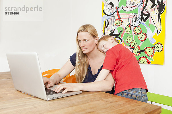 Mutter und Sohn benutzen gemeinsam einen Laptop