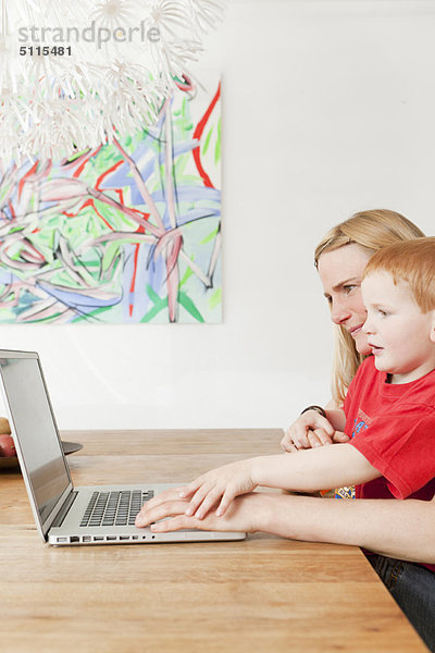 Mutter und Sohn benutzen gemeinsam einen Laptop