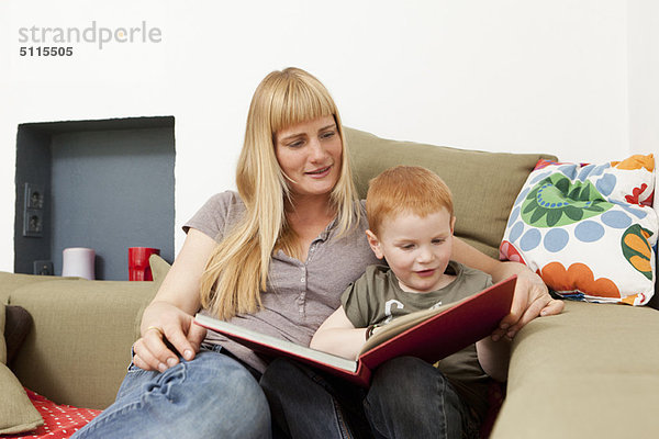 Mutter und Sohn beim gemeinsamen Lesen auf dem Sofa